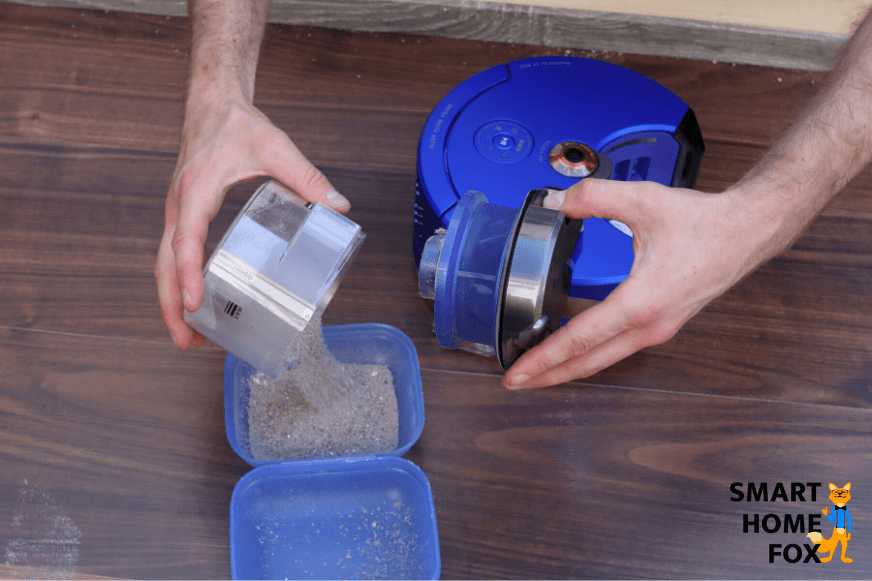 Emptying the mobile dust bin of a robotic vacuum cleaner by hand.